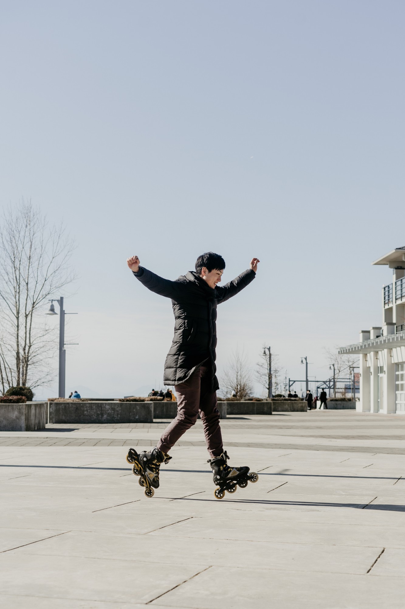 A man on rollerblades with his hands in the air.